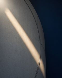 A curved concrete wall in blue shadow